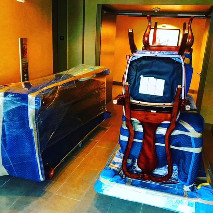 Movers wrapping a chair for an apartment move in Atlanta and around Georgia